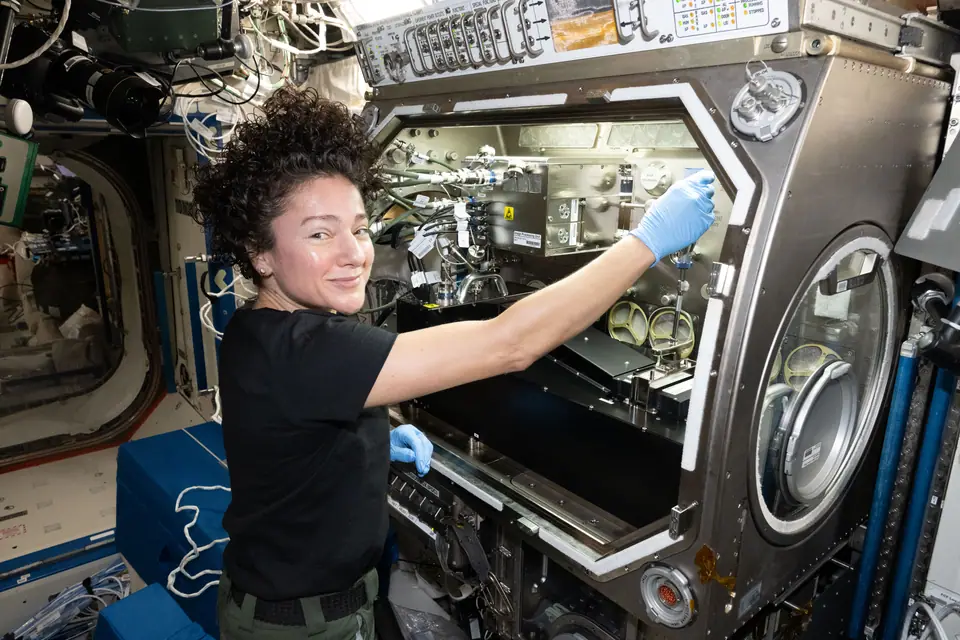 La astronauta Jessica Meir manipula equipo de investigación dentro de la caja de guantes de microgravedad en la Estación Espacial Internacional