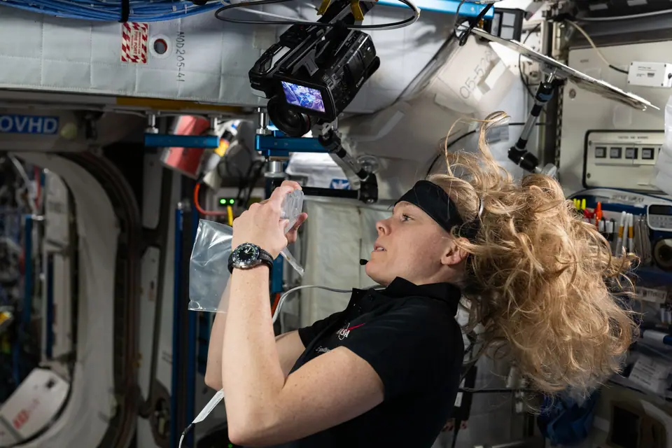 Una astronauta de la NASA trabaja en la Estación Espacial Internacional con el pelo flotando alrededor de la cabeza