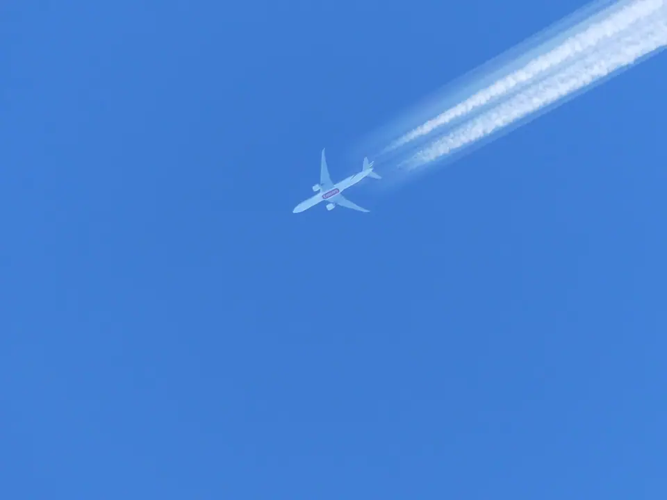 Avión de pasajeros a gran altura dejando cuatro estelas blancas sobre un cielo azul