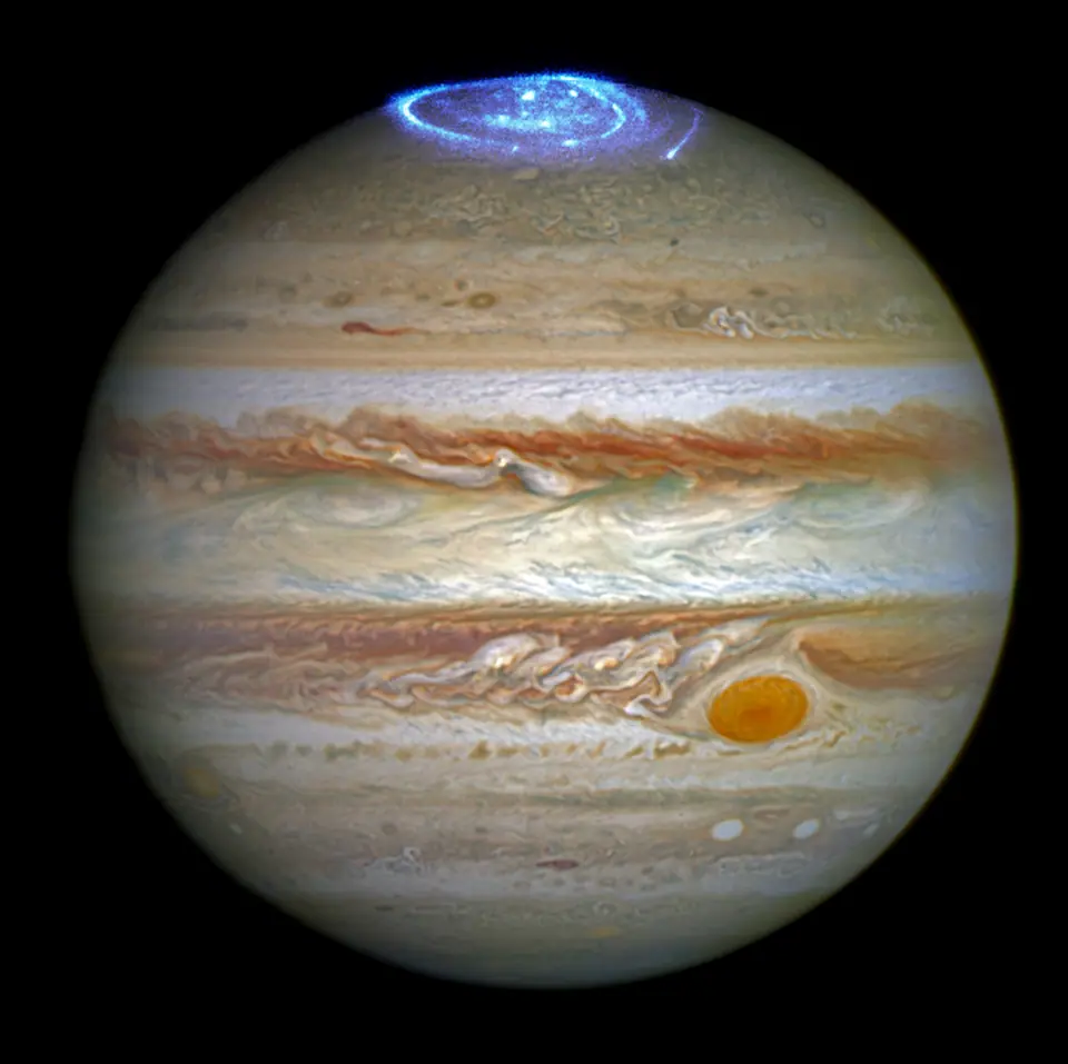 Júpiter visto por el telescopio Hubble, con sus bandas de nubes, la Gran Mancha Roja y una aurora azul sobre el polo norte