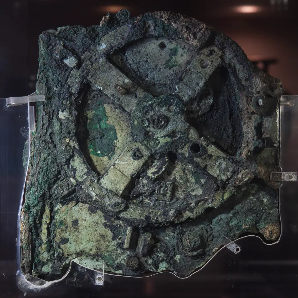 Fragmento principal del mecanismo de Anticitera, bronce verde corroído con una gran rueda dentada de cuatro rayos