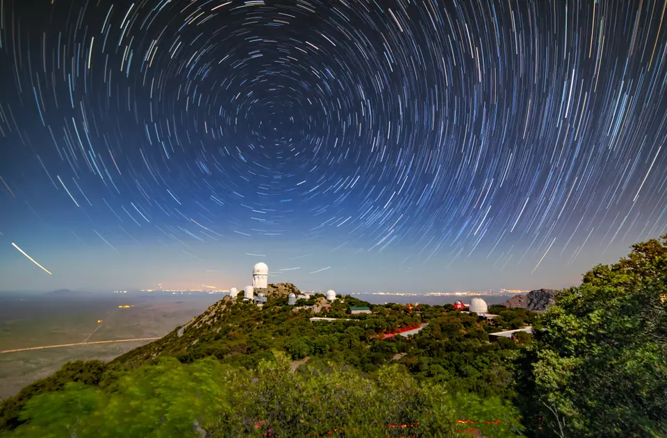 Estelas de estrellas girando alrededor de la Estrella Polar sobre un observatorio