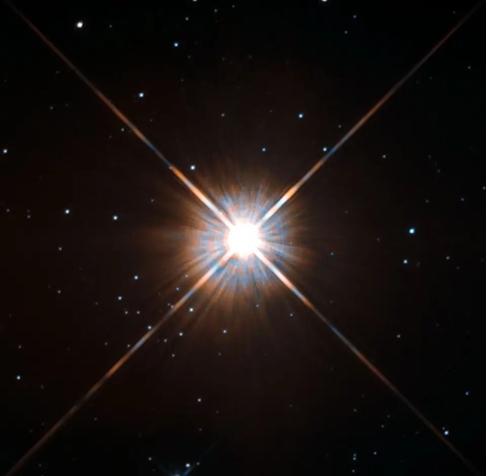 Proxima Centauri fotografiada por el telescopio espacial Hubble: una estrella roja brillante con rayos de difracción sobre un fondo de estrellas