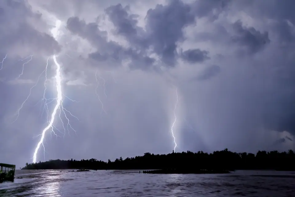Dos rayos caen sobre el lago de Maracaibo, en Venezuela, de noche, bajo un cielo nublado iluminado por los relámpagos del Catatumbo