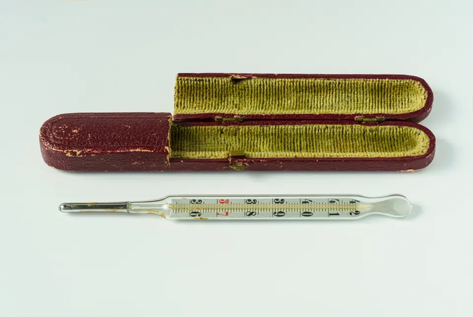 Termómetro clínico de vidrio antiguo junto a su estuche forrado